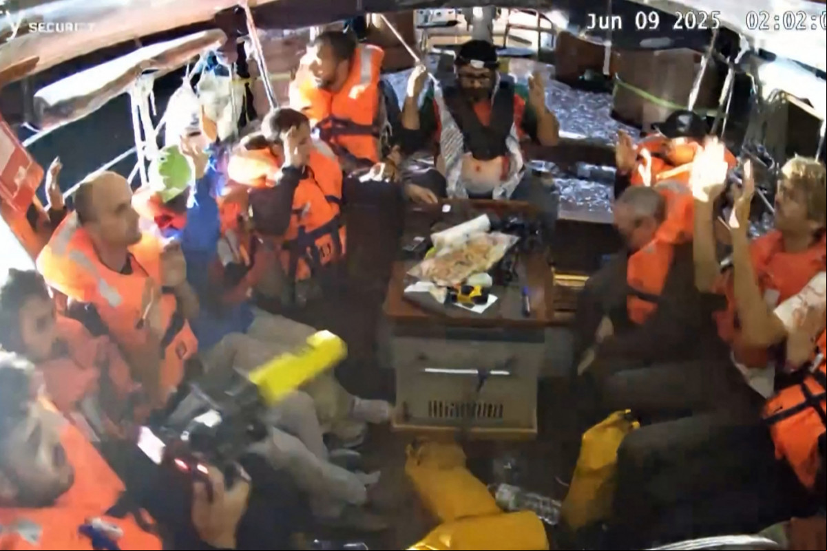 Uma imagem capturada de um vídeo divulgado pela Coalizão da Flotilha da Liberdade em 9 de junho de 2025 mostra ativistas a bordo do barco de ajuda humanitária Madleen, com as mãos no ar, com destino a Gaza, sendo interceptados pelas forças israelenses em águas internacionais antes de chegarem ao território palestino bloqueado. O barco foi redirecionado para a costa israelense, impedindo que os ativistas a bordo, incluindo a ativista sueca Greta Thunberg e a parlamentar europeia Rima Hassan, chegassem à Faixa de Gaza. (Foto da Coalizão da Flotilha da Liberdade / AFP) ( AFP) Uma imagem capturada de um vídeo divulgado pela Coalizão da Flotilha da Liberdade em 9 de junho de 2025 mostra ativistas a bordo do barco de ajuda humanitária Madleen, com as mãos no ar, com destino a Gaza, sendo interceptados pelas forças israelenses em águas internacionais antes de chegarem ao território palestino bloqueado. O barco foi redirecionado para a costa israelense, impedindo que os ativistas a bordo, incluindo a ativista sueca Greta Thunberg e a parlamentar europeia Rima Hassan, chegassem à Faixa de Gaza. (Foto da Coalizão da Flotilha da Liberdade / AFP)/ AFP