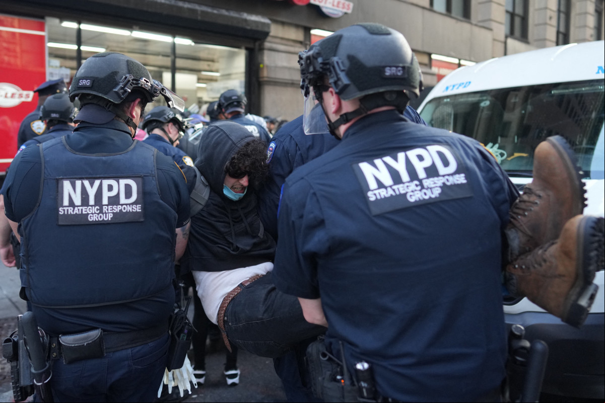 Policiais da polícia de Nova York detêm um manifestante durante um protesto contra o Serviço de Imigração e Alfândega dos EUA (ICE) e operações federais de imigração