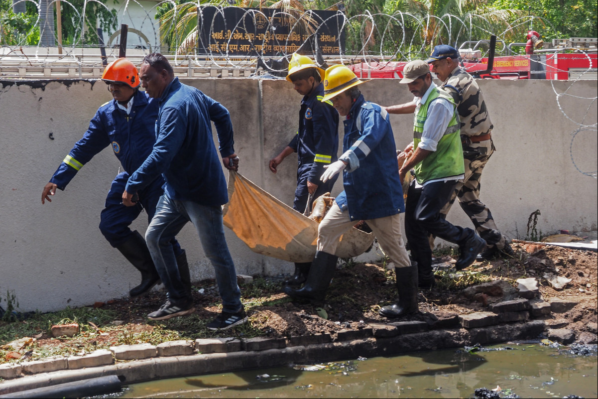 Bombeiros carregam o corpo de uma vítima após o voo 171 da Air India cair em uma área residencial perto do aeroporto de Ahmedabad, em 12 de junho de 2025. O avião de ageiros com destino a Londres caiu em 12 de junho na cidade de Ahmedabad, no oeste da Índia, com 242 pessoas a bordo, disseram autoridades da aviação, no que a companhia aérea chamou de Bombeiros carregam o corpo de uma vítima após o voo 171 da Air India cair em uma área residencial perto do aeroporto de Ahmedabad, em 12 de junho de 2025. O avião de ageiros com destino a Londres caiu em 12 de junho na cidade de Ahmedabad, no oeste da Índia, com 242 pessoas a bordo, disseram autoridades da aviação, no que a companhia aérea chamou de